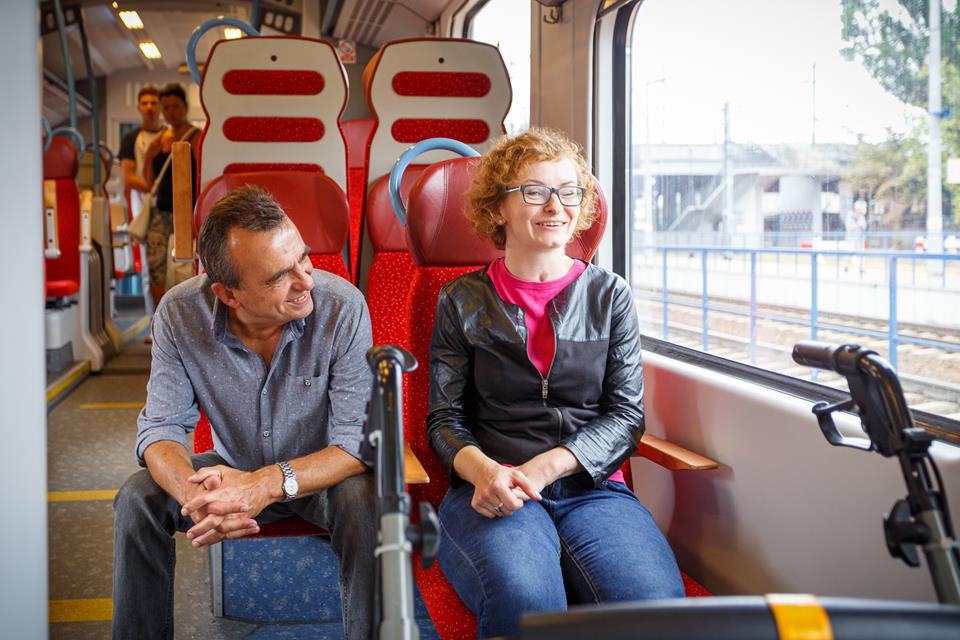 Podróżny i osoba asystująca jadący pociągiem